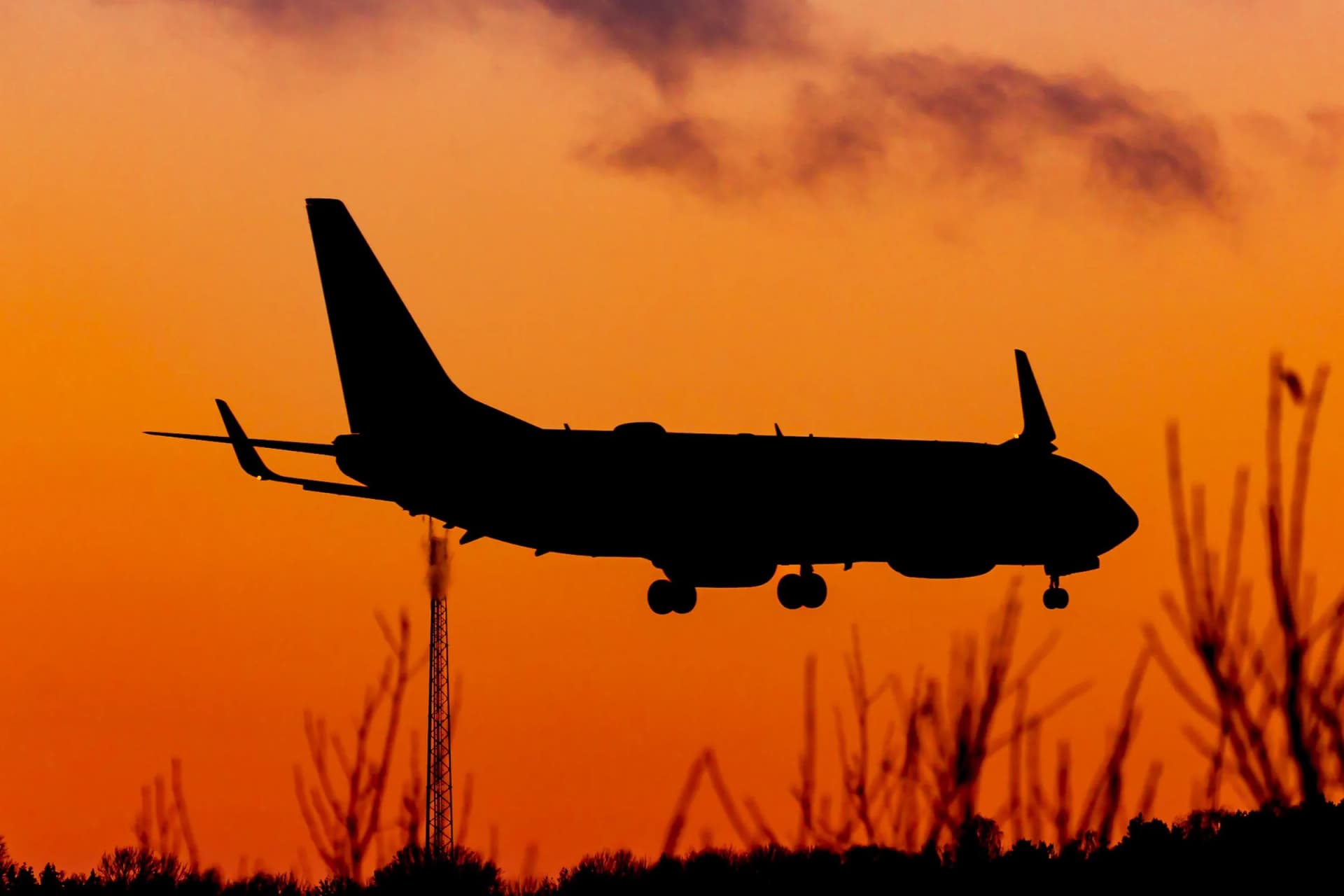 Aircraft landing against an orange sky